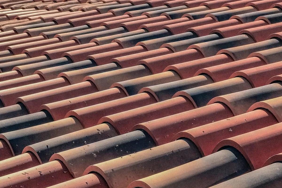 Close-up of overlapping roof tiles checked during an inspection