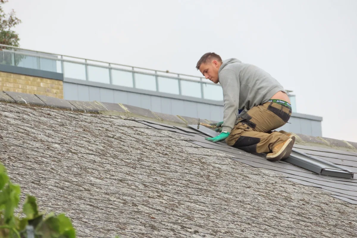 Roofer installing new shingles on a roof deck